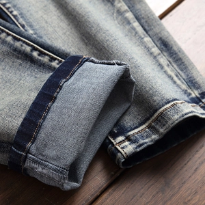 Slim fit blue denim jeans for men with snow wash texture and cuffed hem detail