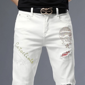 Détail de jean blanc slim avec crâne en strass et motif de broderie tendance