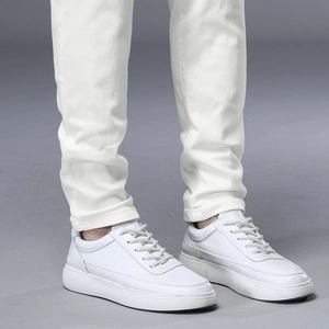 Vue détaillée de baskets minimalistes en cuir blanc avec texture de couture latérale