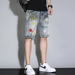 Close-up of retro blue denim shorts featuring colorful star embroidery and washed texture