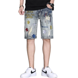 Close-up of vintage blue denim shorts with colorful star and letter embroidery details