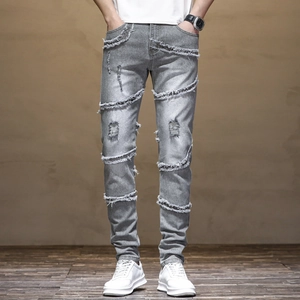 Close-up of distressed gray slim jeans featuring ripped knee details and frayed edges