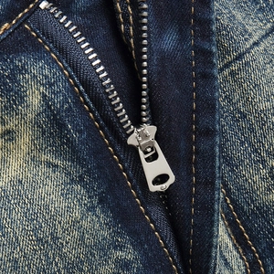 Close-up of vintage wash denim shorts featuring a silver metal zipper and contrast stitching