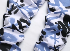 Gros plan sur l'imprimé graffiti bleu et noir sur le pantalon en jean blanc stretch