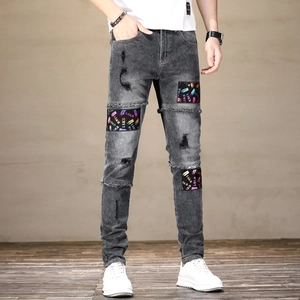Jeans ajusté gris fumé pour hommes avec patchs de lettres colorés et détails déchirés