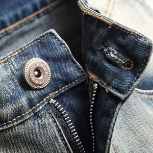Gros plan de la taille d'un jean avec bouton métallique et braguette à glissière