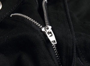 Close-up of silver metal zipper and black twill denim fabric on men's jeans