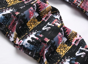 Detailed macro view of the abstract graffiti print and fabric texture on denim pants