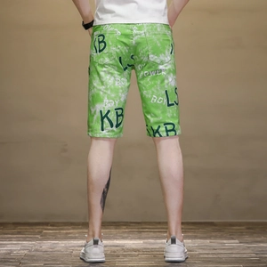 Détail du short décontracté vert pour homme avec motif tie-dye et lettrage graffiti