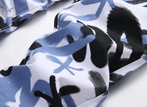 Gros plan sur le pantalon blanc de style urbain avec imprimé graffiti bleu et noir