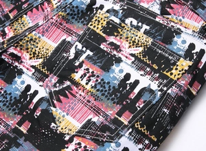 Detail of colorful graffiti print on denim fabric with pentagon back pocket and stitching
