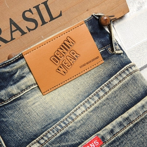 Vintage wash men's denim shorts featuring a brown leather patch and premium stitching