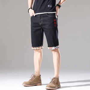 Detailansicht der Denim-Shorts mit roter Stickerei und geometrischem Muster am Saum