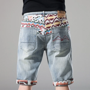 Detail of light blue denim shorts with colorful ethnic pattern on back yoke and red W-stitching