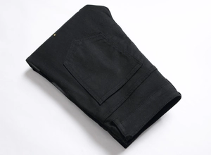 Detailed close-up of black slim fit denim jeans showing fabric texture and back pocket