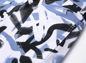 Détail de l'imprimé graffiti sur un jean stretch avec des doubles coutures blanches