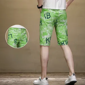 Détail du short tie-dye vert avec des imprimés de lettres et chiffres vert foncé