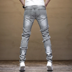 Rear view of slim fit light gray biker jeans with distressed moto paneling details