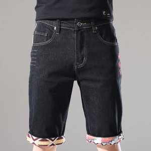 Detail der schwarzen Denim-Shorts mit roter Stickerei und geometrisch gemusterten Säumen
