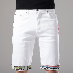 Dettaglio degli shorts in denim bianco con risvolto geometrico e ricamo rosso