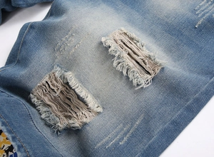 Gros plan détaillé du tissu denim bleu délavé et déchiré pour short homme été