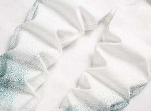 Détail d'un pantalon en denim blanc avec des éclaboussures de peinture bleu sarcelle