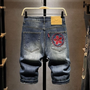 Men's blue denim shorts featuring koi-inspired floral embroidery and washed finish