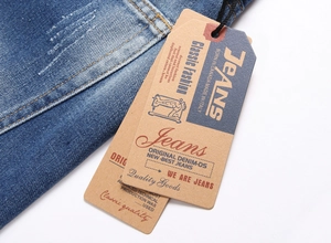 Detailed macro view of mid-blue washed denim fabric with distressed whiskers and vintage tags