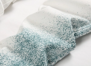 Vue macro du tissu denim blanc avec des motifs de peinture éclaboussée vert foncé
