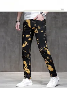 Detail of slim fit men's jeans featuring gold abstract print and sharp denim texture