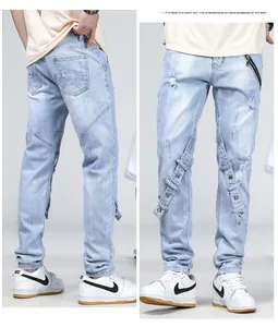 Détail du jean slim bleu clair avec sangles décoratives en denim et œillets métalliques