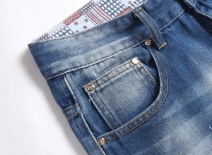Detailed close-up of denim shorts featuring washed fabric and star pattern lining on waistband