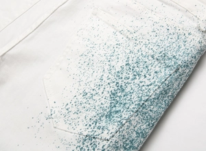 Gros plan sur le jean en denim blanc avec éclaboussures de peinture verte sur la poche