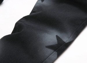 Detailed view of black denim fabric with grey star print and high-quality twill texture