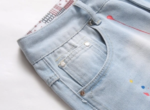Close-up of denim shorts featuring colorful paint splatters and star-patterned lining