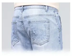 Détail de jean bleu clair avec poches arrière usées et texture délavée