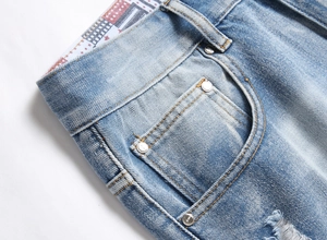 Detailed macro view of light blue denim fabric with metal rivets and pockets on summer shorts