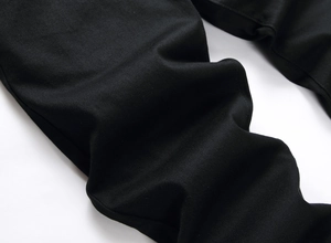 Gros plan détaillé montrant la texture sergé noir profond et le tissu du jean pour homme