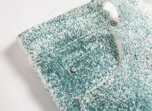 Détail d'un jean blanc de style urbain avec des taches vertes et des rivets métalliques