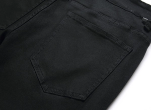 Gros plan détaillé sur les doubles coutures renforcées de la poche arrière du jean noir