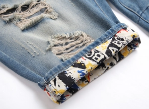 Détail de short en jean déchiré avec imprimé graffiti coloré sur le revers intérieur de jambe