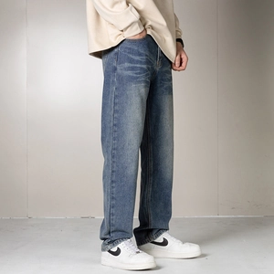 Détail du jean bleu pour homme avec des textures de moustaches délavées classiques