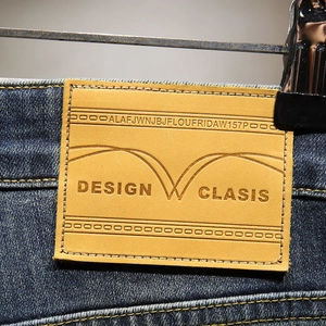 Macro shot of embossed leather waist tag on blue denim shorts with stitched details