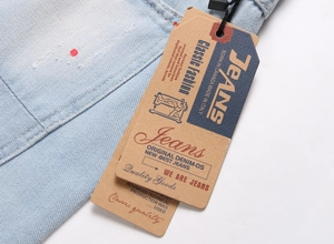 Detailed close-up of light blue washed denim shorts with unique red paint splatter details