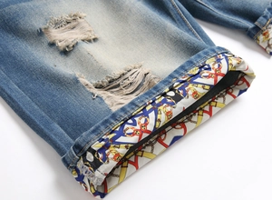 Detailed view of frayed hem denim shorts featuring baroque chain pattern lining detail