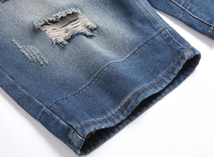Dettaglio macro di pantaloncini di jeans blu da uomo con strappi e cuciture rifinite