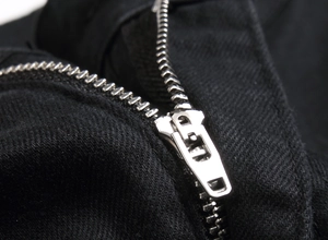 Close-up of durable silver metal zipper on black twill stretch straight denim jeans
