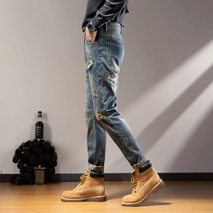 Slim fit men's light blue distressed jeans with vintage wash and ripped patch details