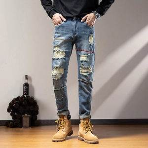 Men's slim fit distressed blue denim jeans with heavy ripped details and street style