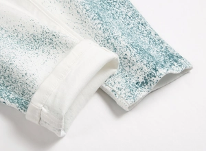 Vue détaillée du jean en denim blanc avec des taches de peinture verte tendance
